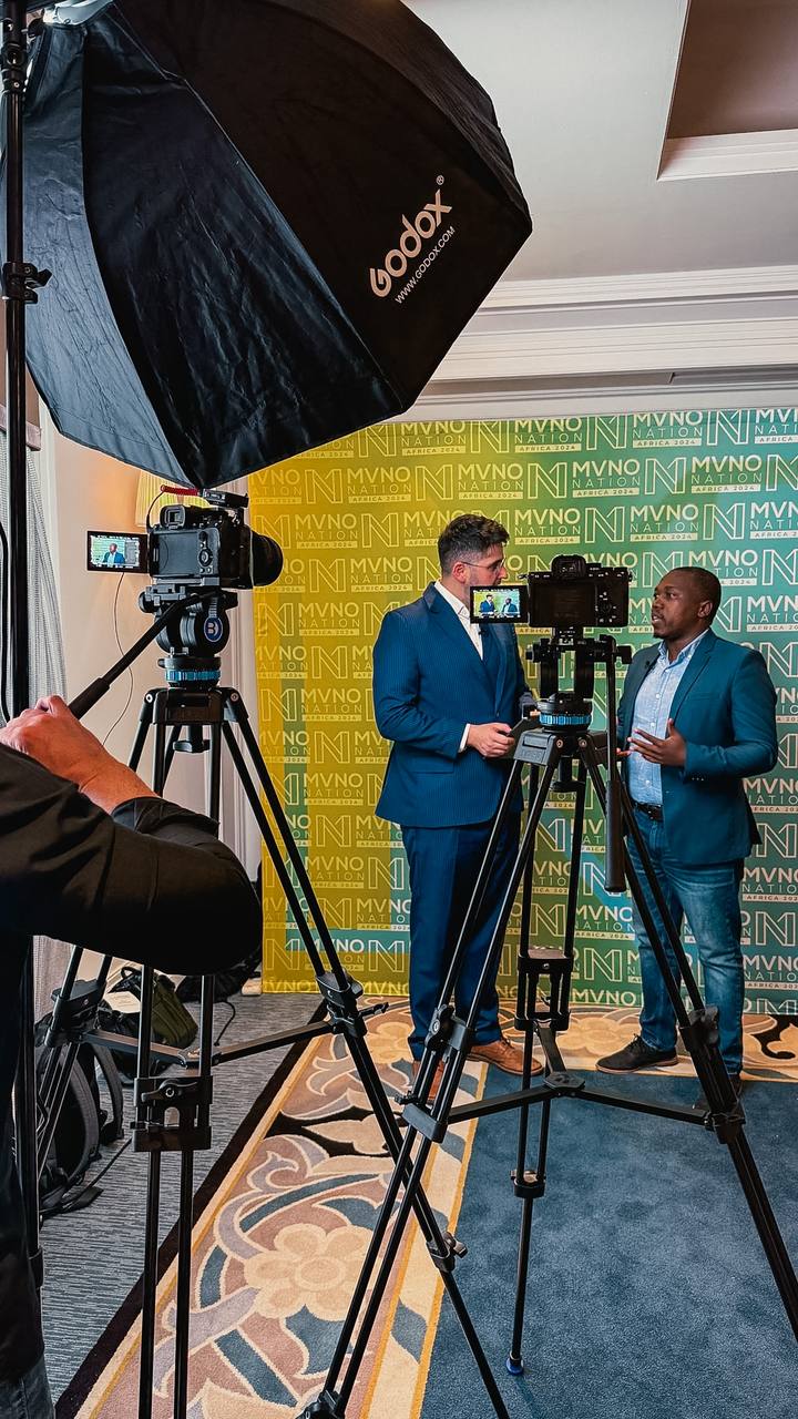 Two-camera interview setup at a conference backdrop